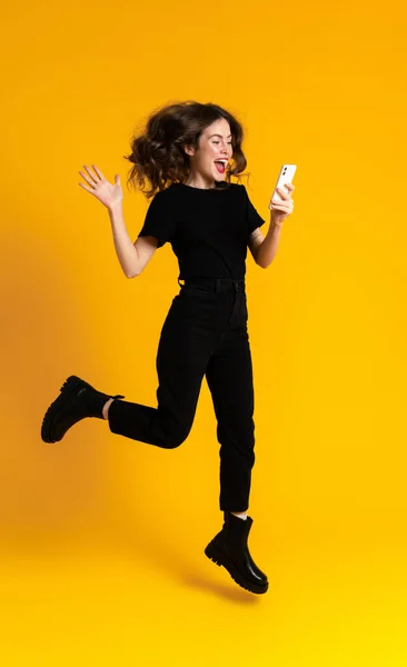 White Young Woman Using Mobile Phone While Gesturing Jumping Isolated —  Fotos de Stock