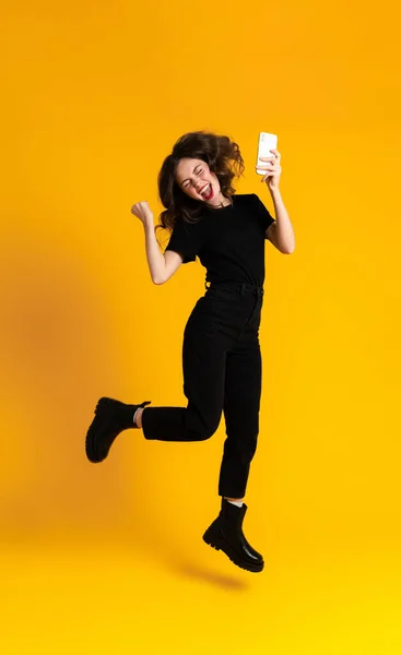 White Young Woman Using Mobile Phone While Gesturing Jumping Isolated —  Fotos de Stock