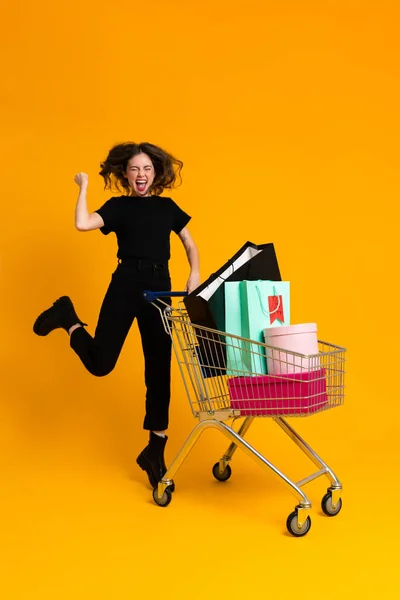 Excited Woman Making Winner Gesture While Posing Shopping Cart Isolated — Photo