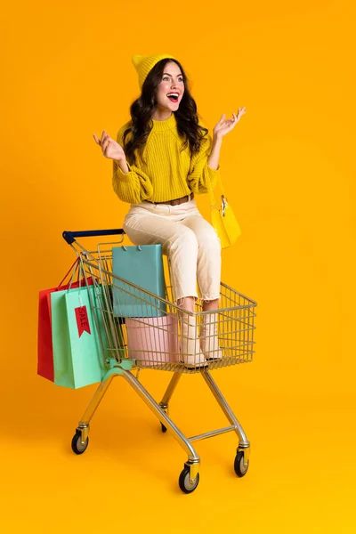 White Woman Gesturing While Sitting Shopping Cart Isolated Yellow Background — Photo