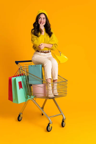 White Woman Smiling While Sitting Shopping Cart Isolated Yellow Background — Φωτογραφία Αρχείου