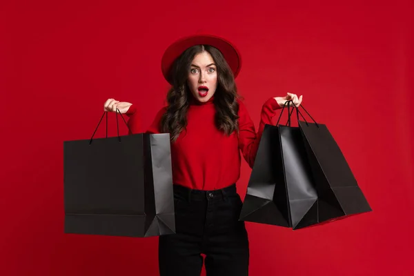 White Woman Expressing Surprise While Posing Shopping Bags Isolated Red — Stock fotografie