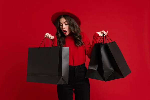White Woman Expressing Surprise While Posing Shopping Bags Isolated Red — Stock fotografie