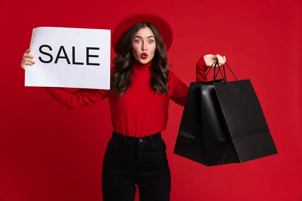 White Surprised Woman Posing Shopping Bags Sale Placard Isolated Red — стоковое фото