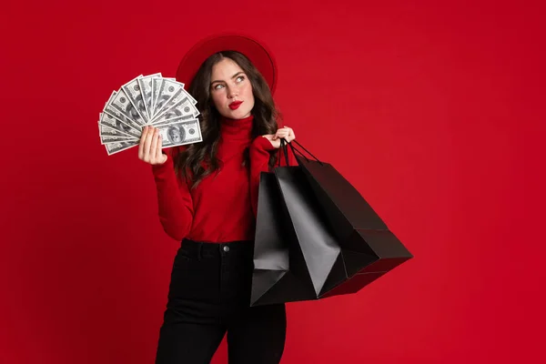 White Puzzled Woman Posing Shopping Bags Dollars Isolated Red Background — Stockfoto
