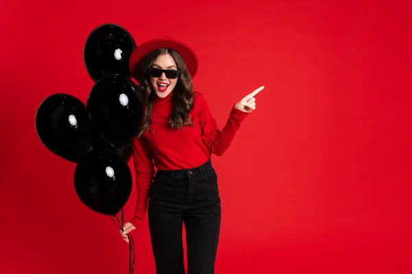 White Woman Pointing Finger Aside While Posing Black Balloons Isolated — Stok fotoğraf