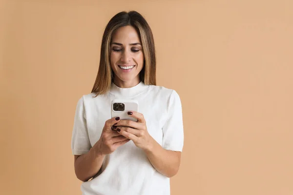 White Mid Woman Wearing Shirt Smiling Using Cellphone Isolated Beige — 图库照片
