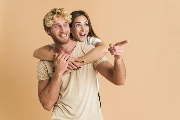 White Couple Wearing Shirts Hugging Pointing Finger Aside Isolated Beige — Foto de Stock