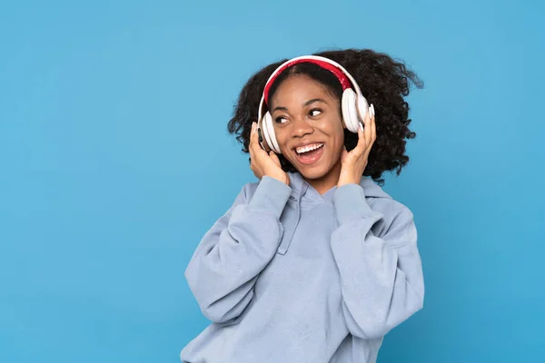 Young Black Woman Smiling While Listening Music Headphones Isolated Blue —  Fotos de Stock
