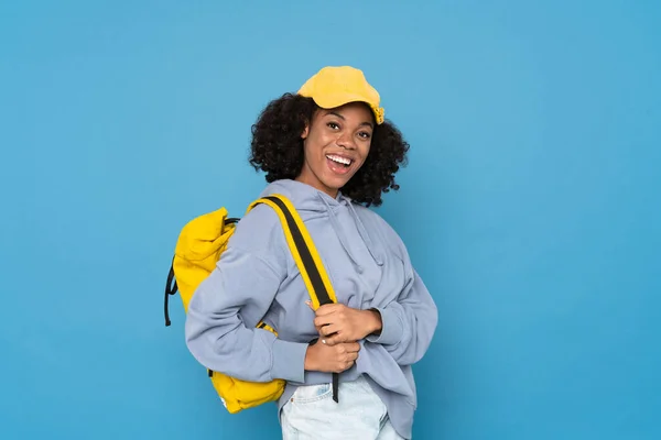 Młoda Czarna Kobieta Uśmiecha Się Podczas Pozowania Plecakiem Izolowanym Niebieskim — Zdjęcie stockowe