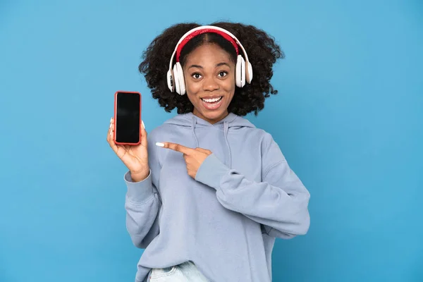 Young Black Woman Headphones Pointing Finger Her Cellphone Isolated White — Fotografia de Stock