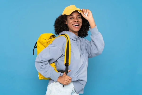 Młoda Czarna Kobieta Uśmiecha Się Podczas Pozowania Plecakiem Izolowanym Niebieskim — Zdjęcie stockowe