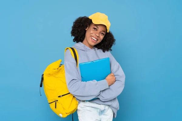 Young Black Woman Smiling While Posing Backpack Folder Isolated Blue — Stockfoto