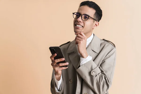 Young Middle Eastern Man Eyeglasses Using Mobile Phone Isolated Beige — Stockfoto