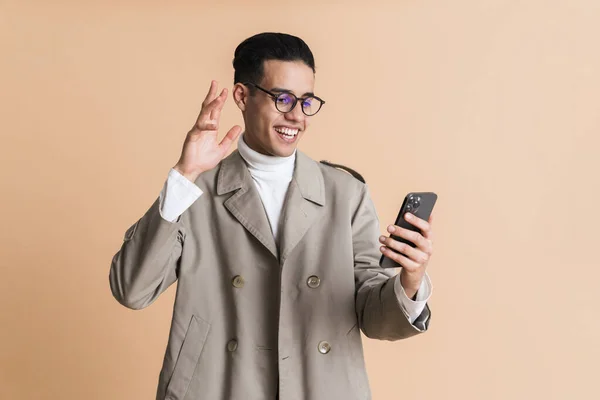 Young Middle Eastern Man Gesturing While Using Mobile Phone Isolated — Stockfoto