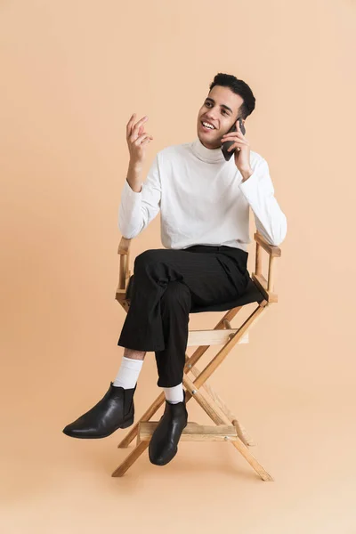 Young Middle Eastern Man Talking Cellphone While Sitting Chair Isolated — Φωτογραφία Αρχείου