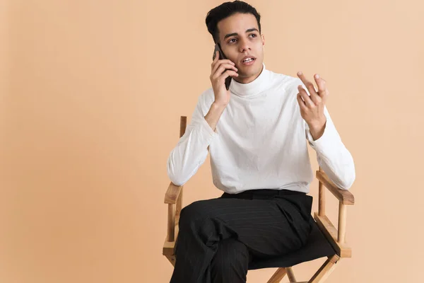 Young Middle Eastern Man Talking Cellphone While Sitting Chair Isolated — Foto de Stock