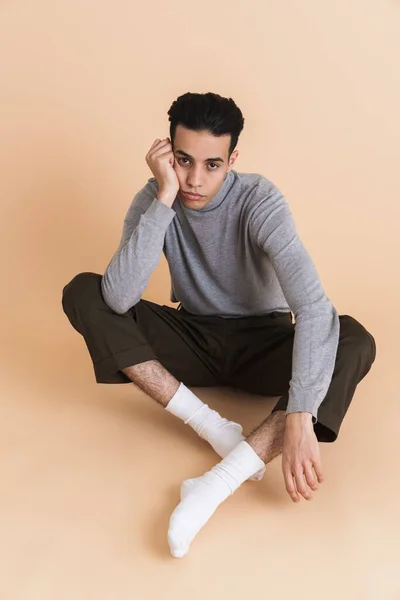 Young Middle Eastern Man Looking Camera While Sitting Floor Isolated — Stock fotografie