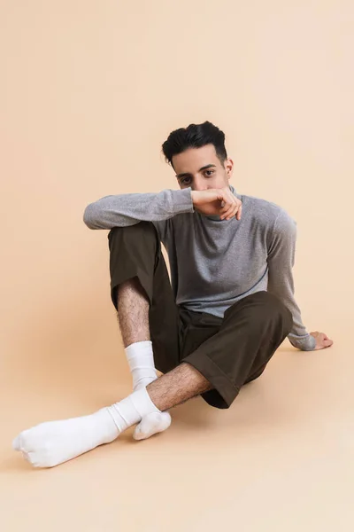 Young Middle Eastern Man Looking Camera While Sitting Floor Isolated — Stockfoto