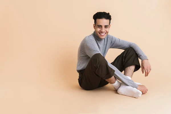 Young Middle Eastern Man Smiling While Sitting Floor Isolated Beige — Stockfoto