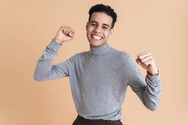 Young Middle Eastern Man Smiling While Making Winner Gesture Isolated — стоковое фото