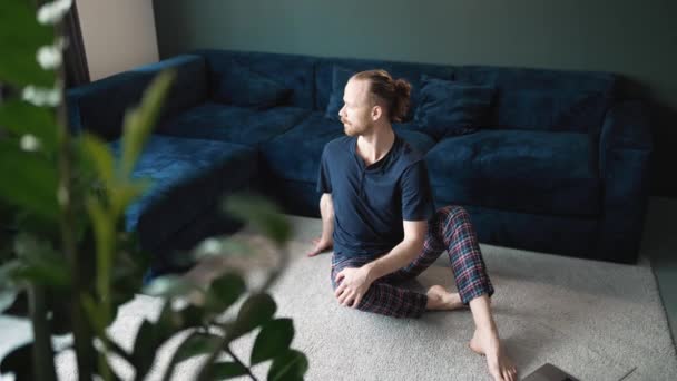 Pleased Blond Man Wearing Pajama Sitting Floor Home — стоковое видео