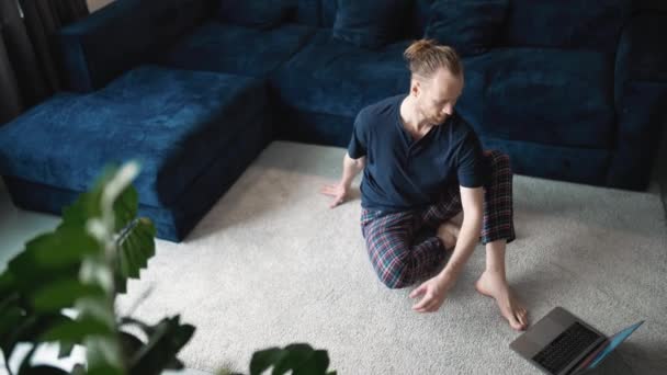 Happy Blond Man Wearing Pajama Doing Stretching Exercises While Sitting — 图库视频影像