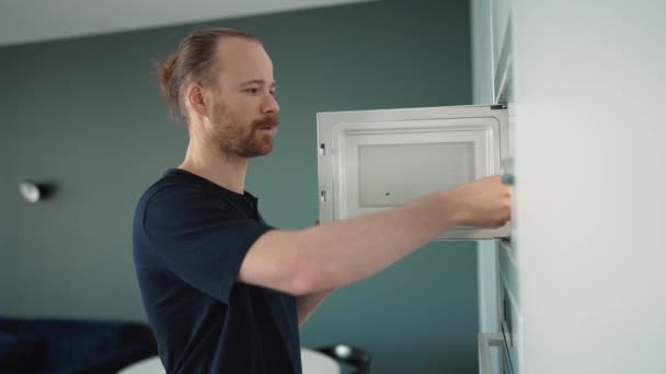 Confident Blond Man Heats Food Microwave Home — Video Stock