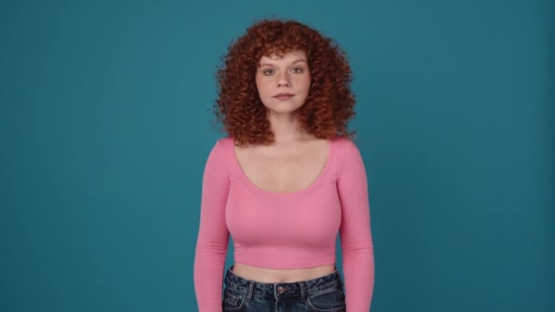 Smiling Curly Haired Redhead Woman Wearing Pink Shirt Looking Camera — Vídeos de Stock