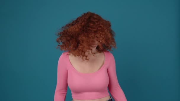 Cheerful Curly Haired Redhead Woman Wearing Pink Shirt Dancing Blue — 图库视频影像