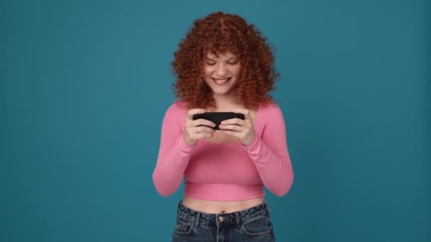 Cheerful Curly Haired Redhead Woman Wearing Pink Shirt Playing Digital — Stockvideo