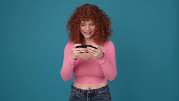 Sad Curly Haired Ginger Woman Wearing Pink Shirt Playing Digital — Vídeo de Stock