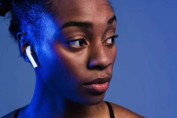 Black Young Sportswoman Earphones Looking Aside Isolated Blue Background — Foto Stock