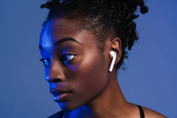 Black Young Sportswoman Earphones Looking Aside Isolated Blue Background — Fotografia de Stock