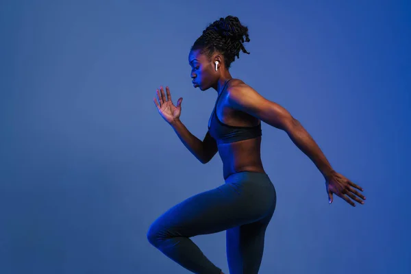 Black Sportswoman Earphones Doing Exercise While Working Out Isolated Blue — Fotografia de Stock
