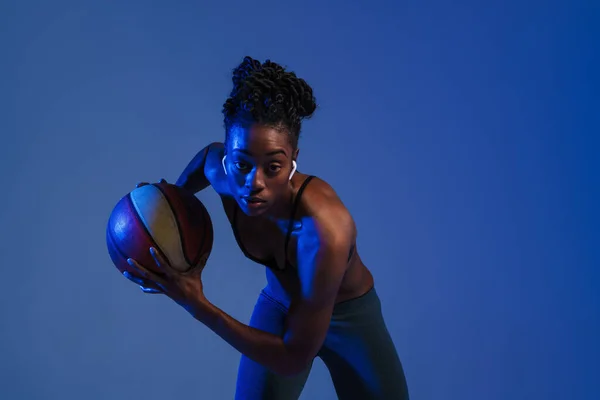 Black Young Sportswoman Earphones Working Out Basketball Isolated Blue Background — Fotografia de Stock