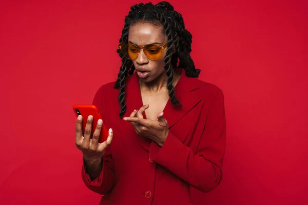 Black Young Woman Frowning While Pointing Finger Her Cellphone Isolated — Fotografia de Stock