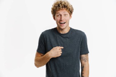 Beyaz duvarın üzerinde kendini gösterip gülen heyecanlı genç adam.