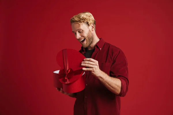 White Man Expressing Surprise While Opening Heart Gift Box Isolated — Stock Photo, Image