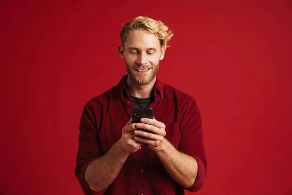 Kırmızı Duvardan Izole Edilmiş Gülümseyen Cep Telefonu Kullanan Beyaz Sakallı — Stok fotoğraf