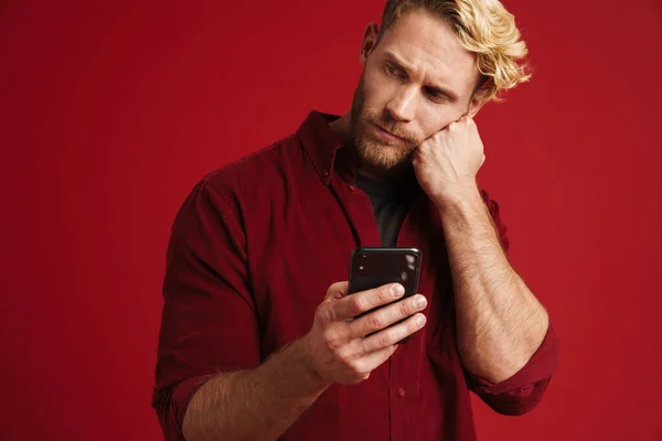 White Puzzled Man Wearing Shirt Using Mobile Phone Isolated Red — Foto de Stock