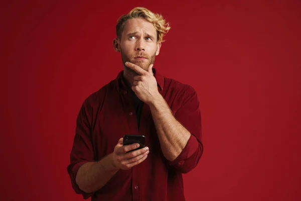 White Puzzled Man Wearing Shirt Using Mobile Phone Isolated Red — Stock Fotó