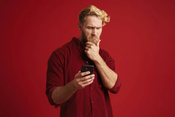 White Puzzled Man Wearing Shirt Using Mobile Phone Isolated Red — 图库照片