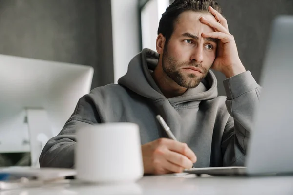 Young Beard Man Working Laptop While Writing Notes Office — Foto de Stock