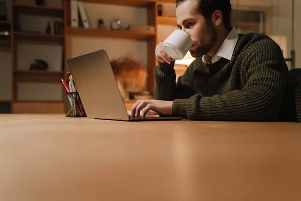 Young Bristle Man Drinking Coffee While Working Laptop Office — Stockfoto