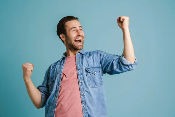 Young Excited Man Screaming While Making Winner Gesture Isolated Blue — Stock fotografie