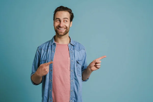 Tişörtlü Genç Adam Gülümsüyor Mavi Arka Planda Izole Edilmiş Parmakları — Stok fotoğraf
