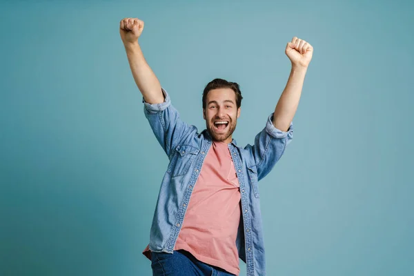 Young Excited Man Screaming While Making Winner Gesture Isolated Blue — Stockfoto