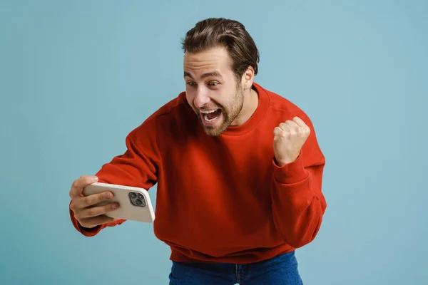 Young Man Making Winner Gesture Taking Selfie Cellphone Isolated Blue — Φωτογραφία Αρχείου