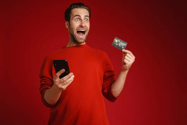 Surprised Man Screaming While Showing Credit Card Cellphone Isolated Red — Photo